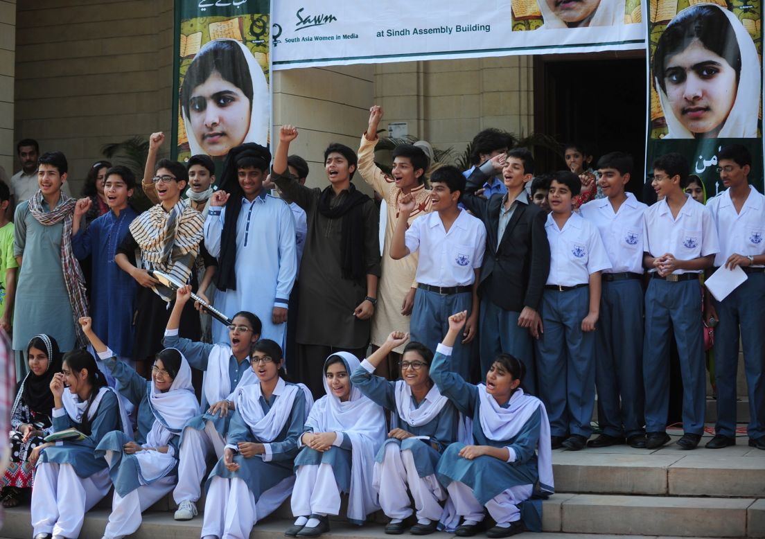 Pakistani students shout slogans near photographs of Malala in Karachi on Saturday.