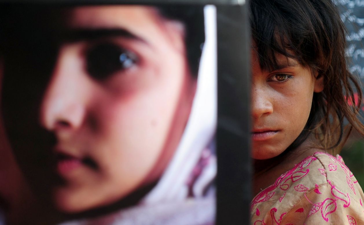 A Pakistani girl carries a photograph of Malala in Karachi to mark Malala Day.