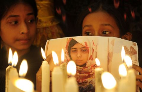 Pakistani supporters hold photographs of Malala as they stand alongside burning candles during a ceremony to mark Malala Day in Karachi on Saturday, November 10, 2012. The teen activist was shot in the head by the Taliban as she rode home from school in a van last month. She had defied the militant group by insisting on the right of girls to go to school. The attack has stirred outrage in Pakistan and around the world.