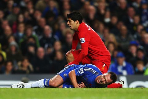 Chelsea captain John Terry is injured after going down in a tackle with Liverpool striker Luis Suarez.