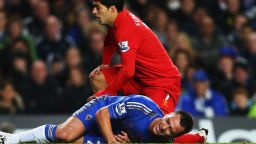 Chelsea captain John Terry is injured after going down in a tackle with Liverpool striker Luis Suarez.