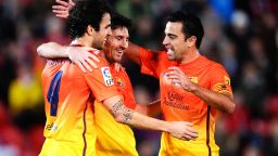 Lionel Messi, center, celebrates with Barcelona teammates Cesc Fabregas, left, and Xavi Hernandez after matching Pele's 75 goals in a calendar year.