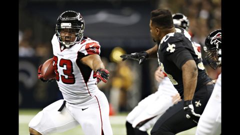 Michael Turner of the Falcons is chased by a helmetless Cameron Jordan of the Saints on Sunday.