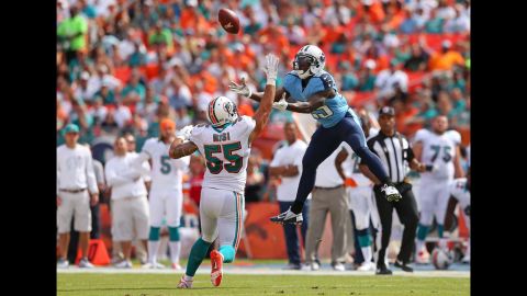 Darius Reynaud of the Tennessee Titans goes up for a catch over Koa Misi of the Miami Dolphins during a game at Sun Life Stadium on Sunday in Miami Gardens, Florida.