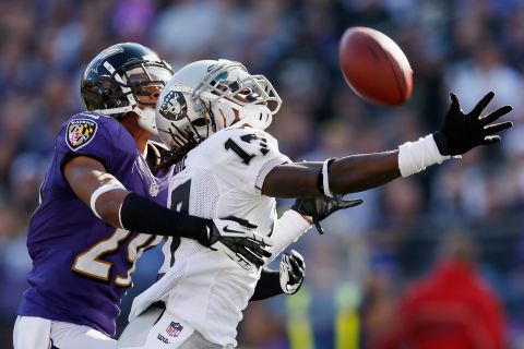 Cornerback Cary Williams of the Ravens breaks up a pass intended for wide receiver Denarius Moore of the Raiders during the first half on Sunday.