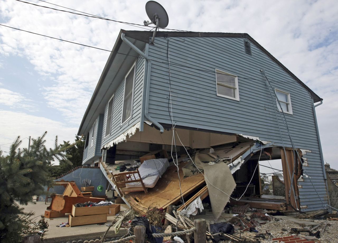 Furniture and other belongings are strewn under and around a beach house damaged by Sandy on Saturday, November 10, in Mystic Island, New Jersey.