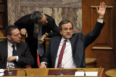 Greek Prime minister Antonis Samaras (R) votes yes for approval of the 2013 budget at the Greek parliament in Athens on November 12, 2012 . 