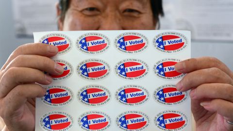 Election official Henry Tung displays a sheet of "I Voted" stickers in several languages at a Los Angeles-area polling station.