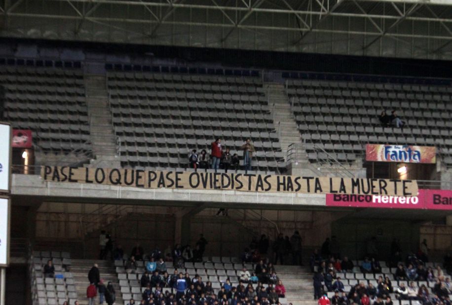 Oviedo fans display a banner: "Happen what may, Oviedistas until death."