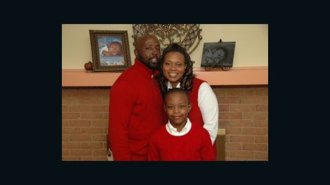 The Cooper family lost their son Alex, pictured behind them, to sudden infant death syndrome.