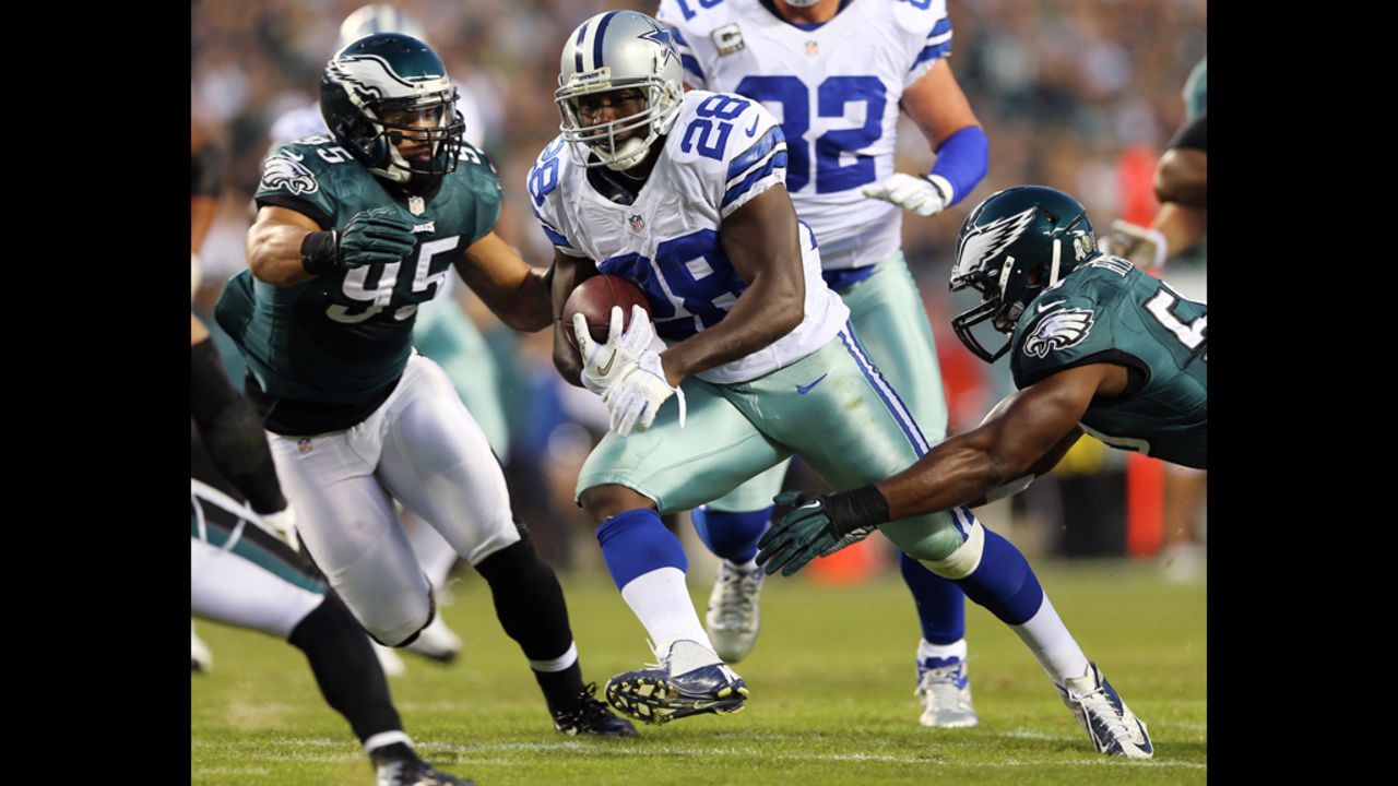 Felix Jones of the Cowboys carries the ball as Mychal Kendricks and DeMeco Ryans of the Eagles defend on Sunday.