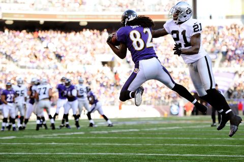 Wide receiver Torrey Smith of the Baltimore Ravens catches a pass for a touchdown past cornerback Ron Bartell of the Oakland Raiders in the third quarter at M&T Bank Stadium on Sunday in Baltimore.