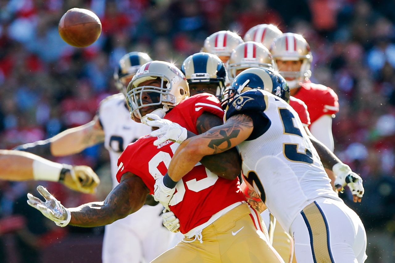 Tight end Vernon Davis of the 49ers bobbles a catch before pulling in the ball as he gets hit by linebacker James Laurinaitis of the Rams in the second quarter on Sunday.