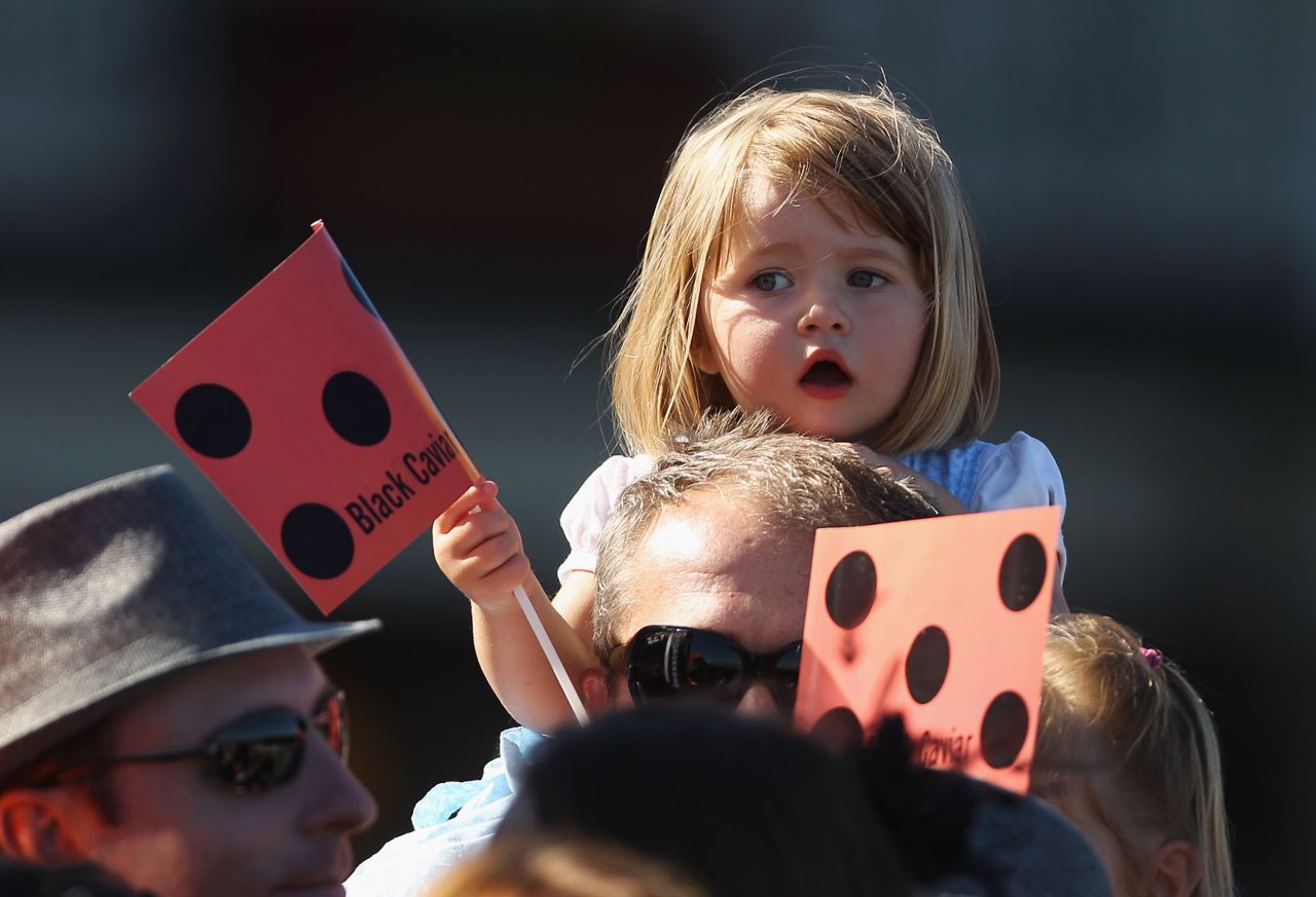 A young racegoer shows her support for Australian horse Black Caviar. The owners chose the name because they thought it appeared sophisticated and stylish.