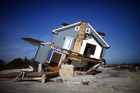 A home damaged by Sandy lists in Mantoloking, New Jersey, on Monday.