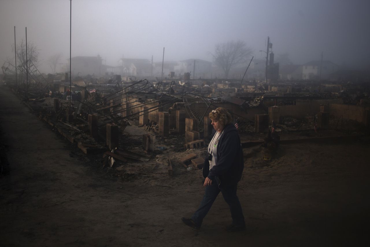 A resident of Breezy Point in Queens walks past houses destroyed by fire during Sandy on Monday. 