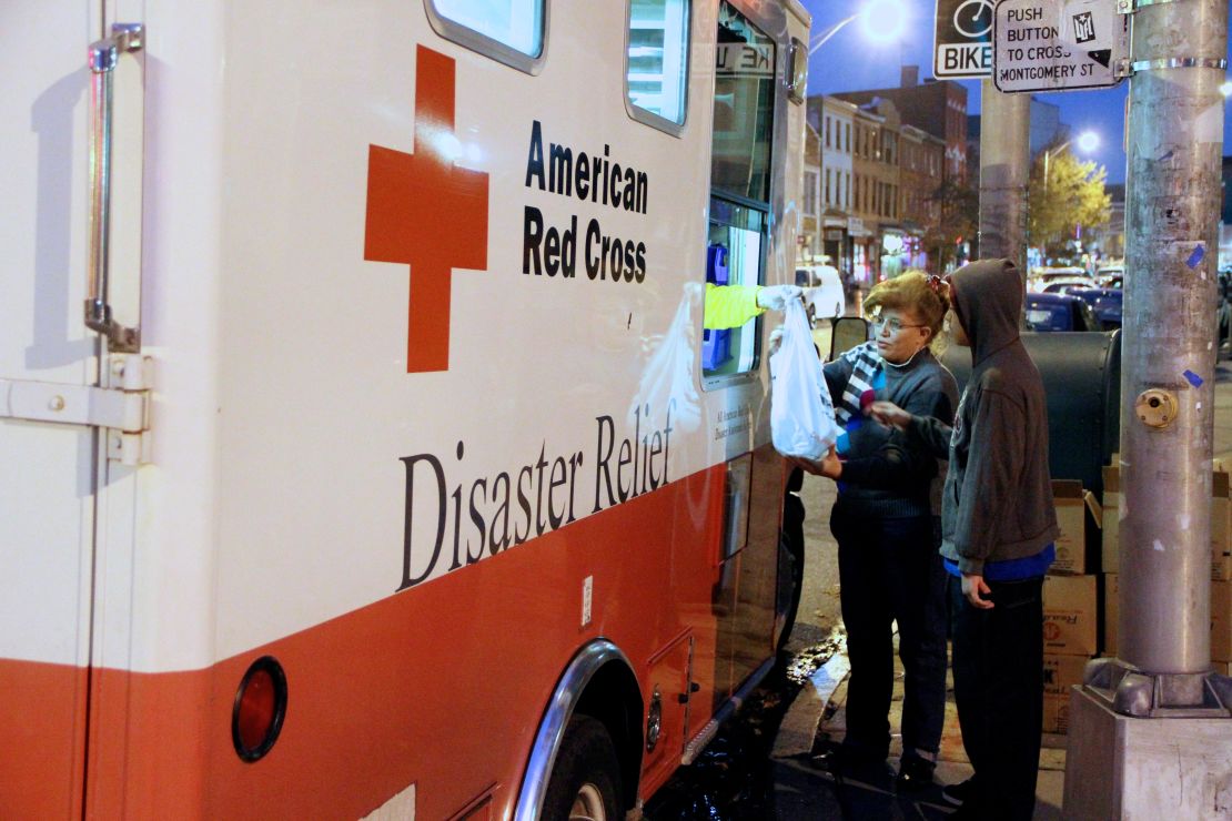 Red Cross personnel distribute food and supplies to storm-affected residents in Jersey City.
