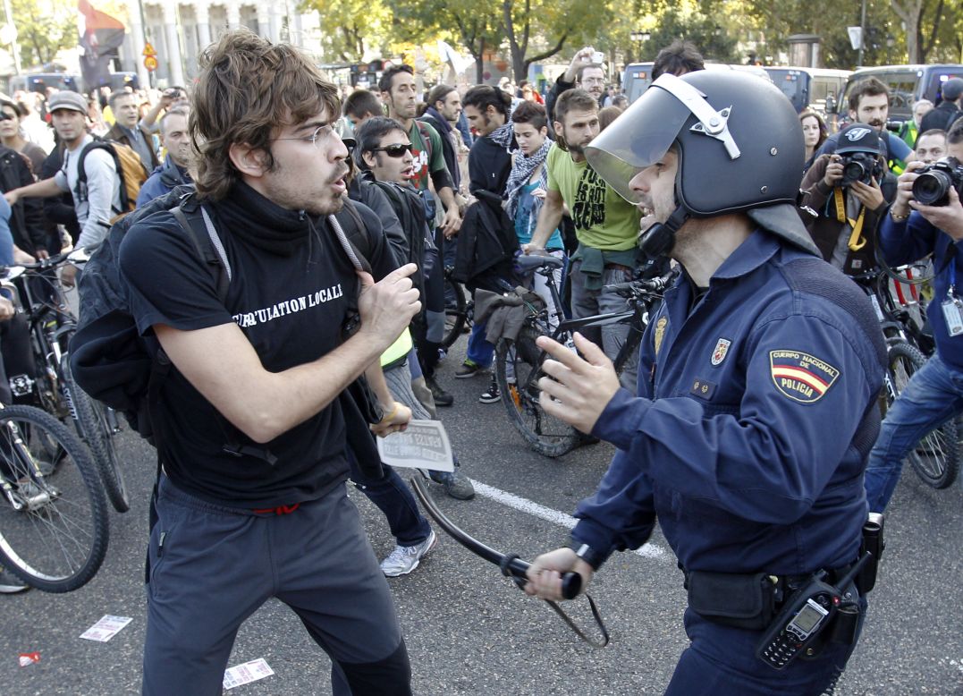 A protester clashes with a riot policeman at Cibeles Square in Madrid.