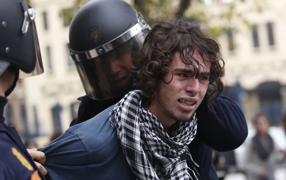 Riot policemen arrest a protester in Valencia on November 14, 2012 during a general strike.