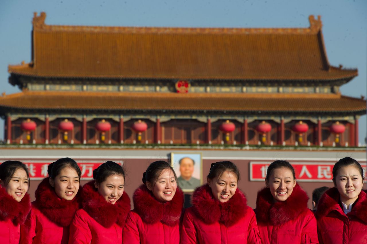 Hostesses pose before the gate to Tiananmen Square as delegates arrive at the Great Hall of the People for the start of the closing ceremony of the Communist Party Congress on November 14.  The week-long congress will end with a transition of power within the party, most notably, introducing new members of the Politburo Standing Committee, which effectively runs China.