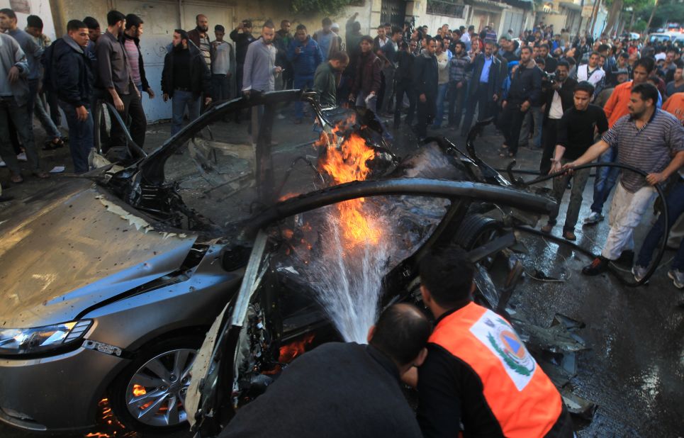 Palestinian firefighters extinguish fire from the car in which al-Jaabari was apparently riding.
