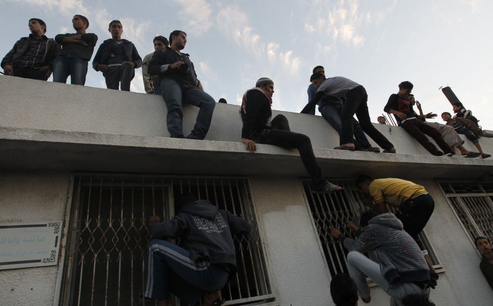 Palestinian youths look inside a building where al-Jaabari's body was brought after the attack.