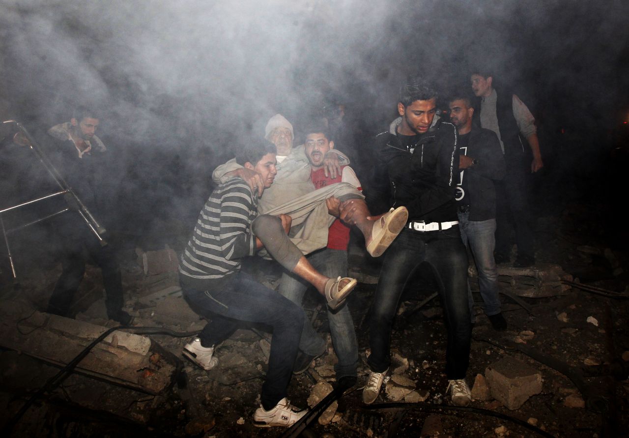 Palestinian youths evacuate an elderly man following an Israeli airstrike.