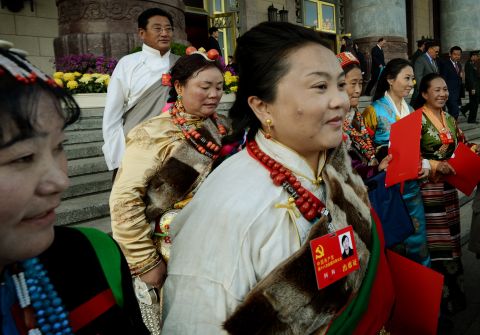 Tibetan delegates carry party documents as they leave the closing ceremony of the Party Congress at the Great Hall of the People in Beijing on November 14.
