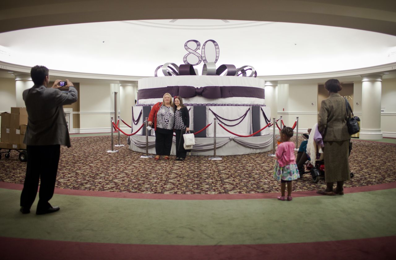 Visitors to First Baptist Church Atlanta stand in front of a birthday cake model honoring Charles Stanley, the church's senior pastor. Stanley, whose televised broadcasts from First Baptist are beamed across the globe, was one of the first pastors to recognize the power of radio and television.