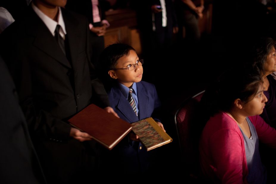 A child lines up with a group of children at First Baptist Church Atlanta, carrying a book written by Charles Stanley. Each child carried one book representing the 45 books written by Stanley during his career. They placed the book on a shelf in front of the sanctuary. 