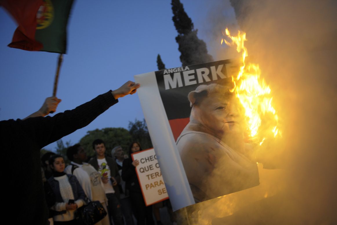 Protesters burn a picture of Angela Merkel in Belem, on the outskirts of Lisbon, on November 12, 2012.