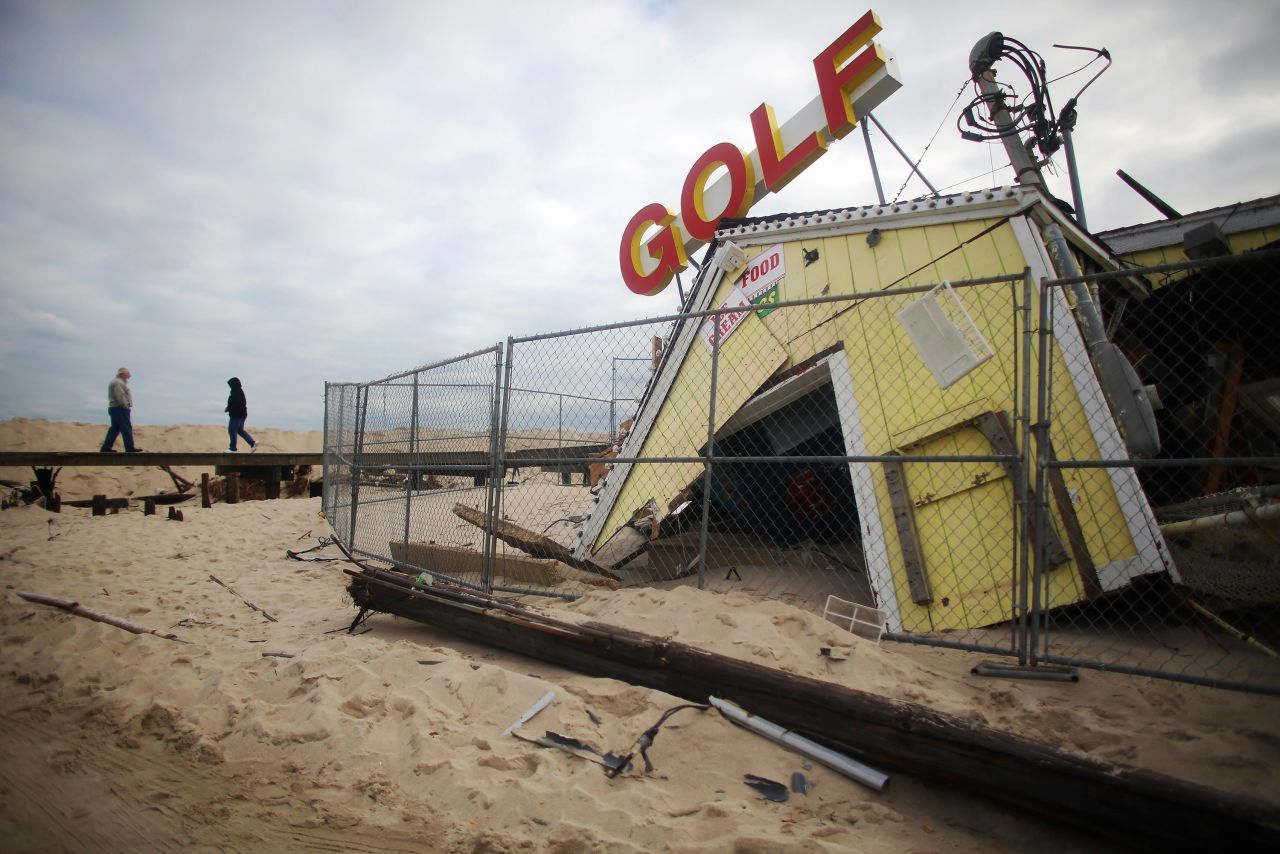People walk past a destroyed miniature golf attraction Wednesday in Point Pleasant, New Jersey.