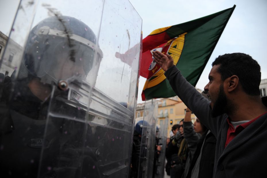 Riot police officers face protesters during a demonstration outside the Portuguese Parliament in Lisbon on November 14, 2012 during a general strike.
