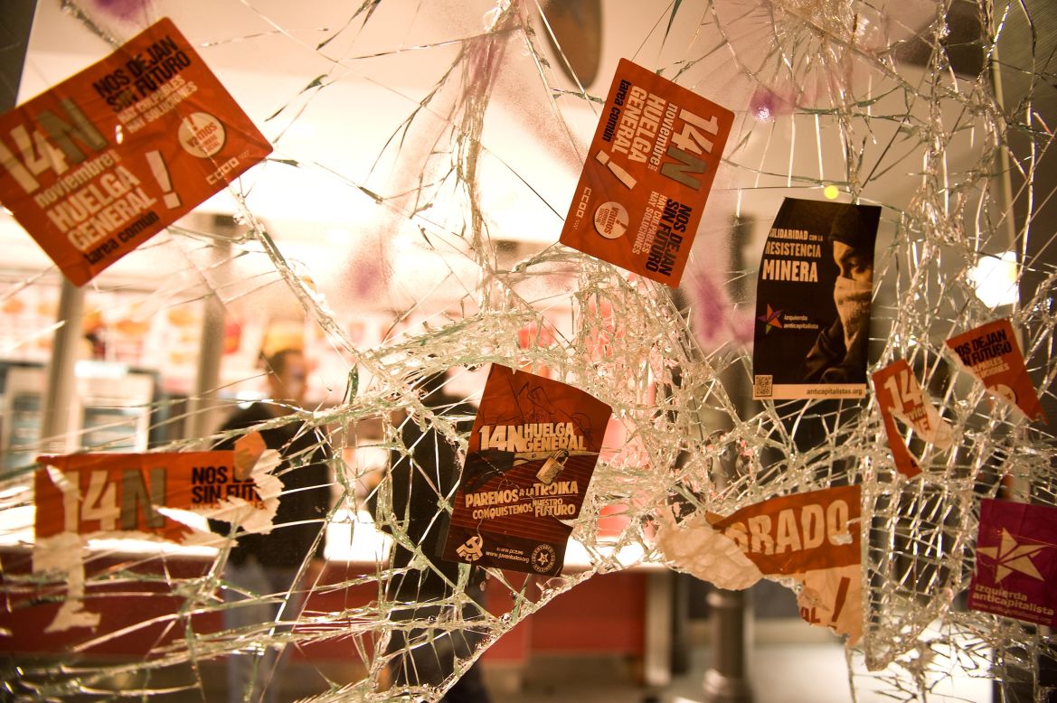Trade union stickers cover the broken window of a Madrid restaurant after a demonstration Wednesday. 