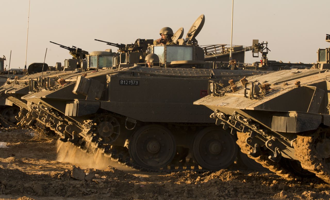Israeli soldiers rest by their armored personnel carriers stationed on the Israel-Gaza border on Thursday, November 15.