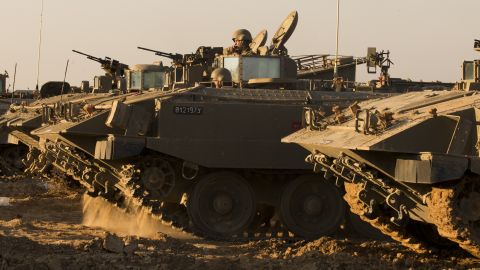 Israeli soldiers rest by their armored personnel carriers stationed on the Israel-Gaza border on Thursday, November 15.