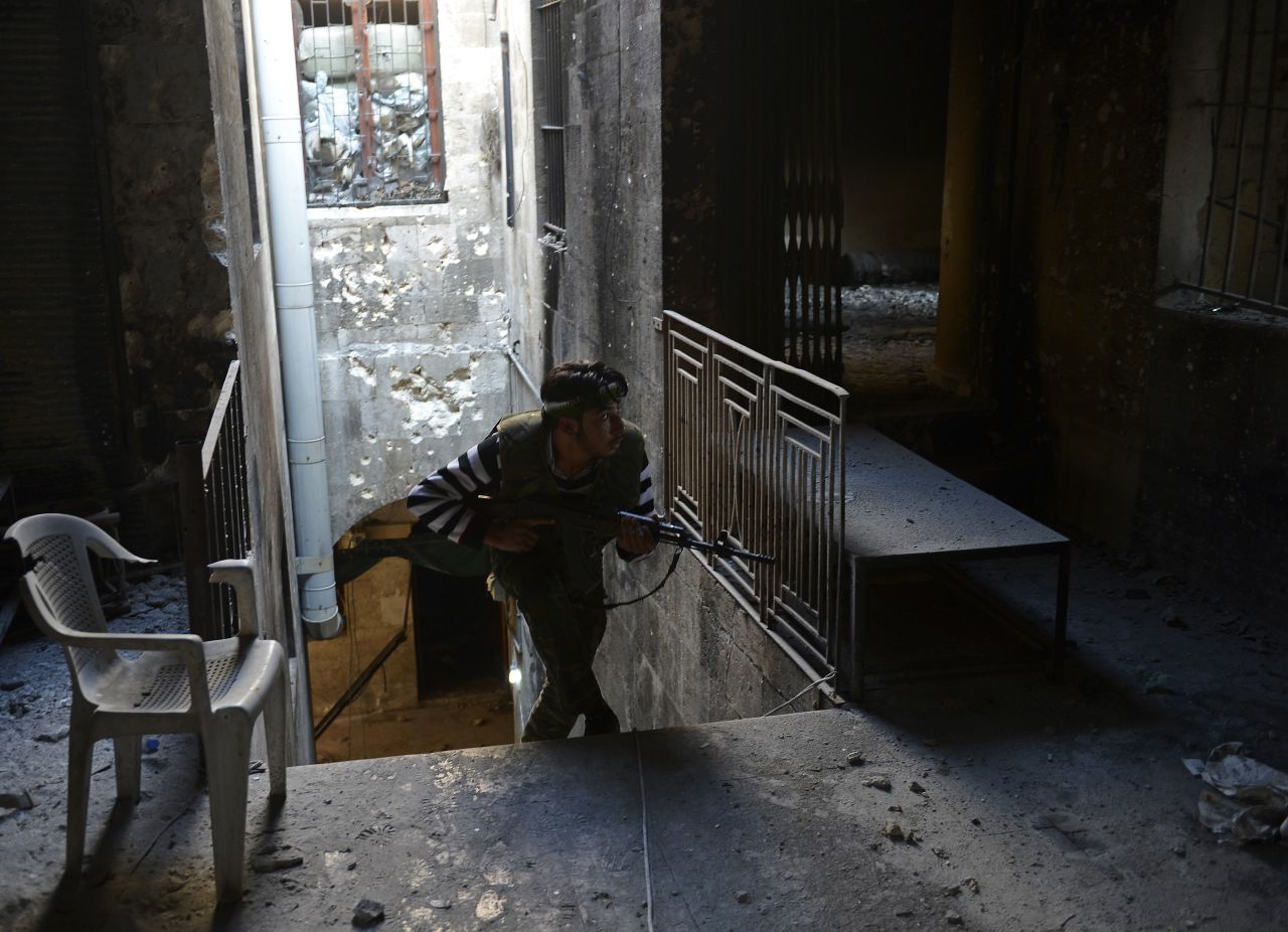 A Syrian rebel takes cover during fighting against Syrian government forces in Aleppo on November 15, 2012.