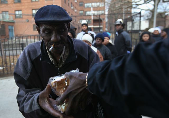 People receive free sandwiches from a mobile food distribution center in the Rockaway neighborhood of Queens, New York, on Thursday.