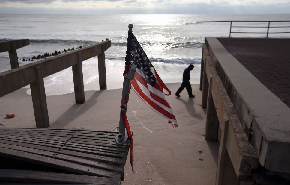 A tattered U.S. flag flies over the storm-damaged boardwalk in the Rockaway section of Queens on Thursday.