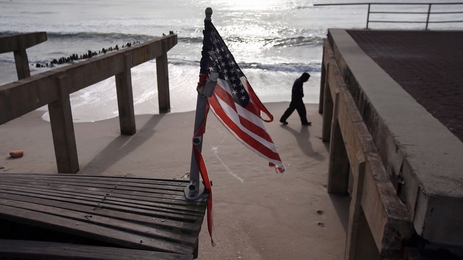A tattered flag flies over the storm-damaged boardwalk in Rockaway, Queens, on Thursday.