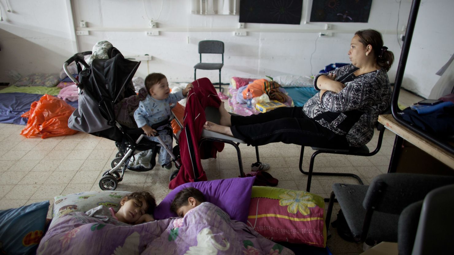 An Israeli woman and children sit inside a bomb shelter on November 14, 2012 in Netivot, Israel.