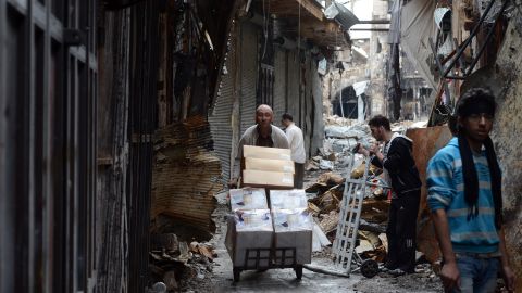 A Syrian man moves his belongings from his damaged shop in the old city of Aleppo on November 12, 2012