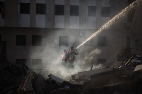 Palestinian firefighters try to extinguish a fire at the Civilian Affairs branch of the Ministry of Interior on Friday, November 16.