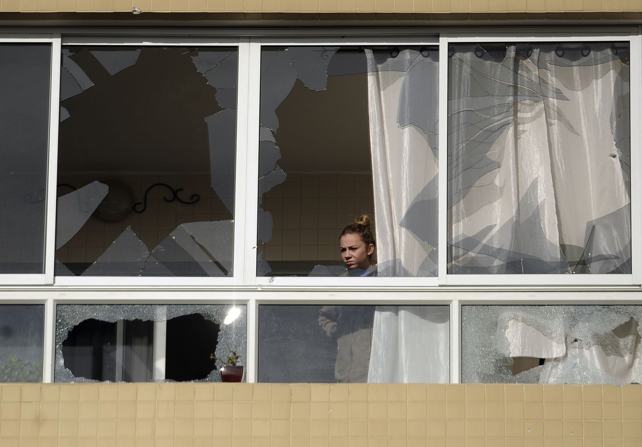 An Israeli woman looks out from an apartment building in Ashdod, Israel, damaged by a rocket fired by Palestinian militants on Friday, November 16.