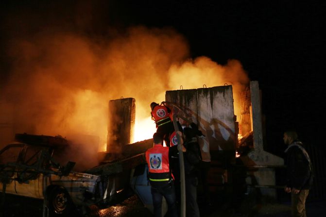 Palestinians extinguish a fire after Israeli air strikes targeted an electricity generator that fed the house of Hamas's Prime Minister Ismail Haniyeh in Gaza City, on Thursday, November 15.