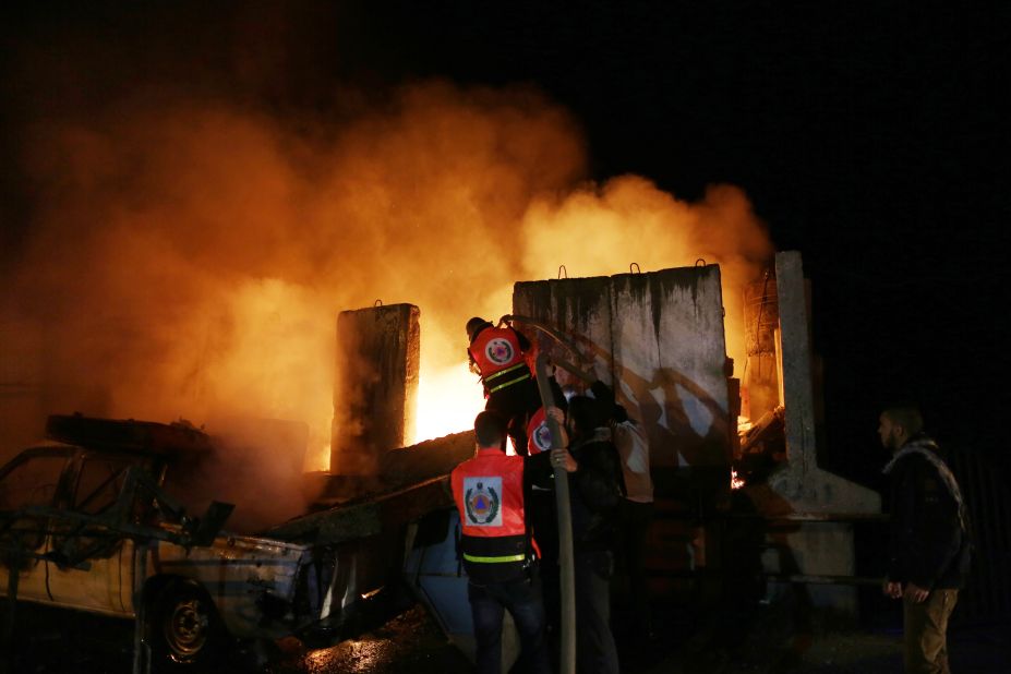 Palestinians extinguish a fire after Israeli air strikes targeted an electricity generator that fed the house of Hamas's Prime Minister Ismail Haniyeh in Gaza City, on Thursday, November 15.