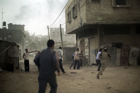 Palestinians run for cover after an Israeli airstrike hits Gaza City on Friday, November 16.