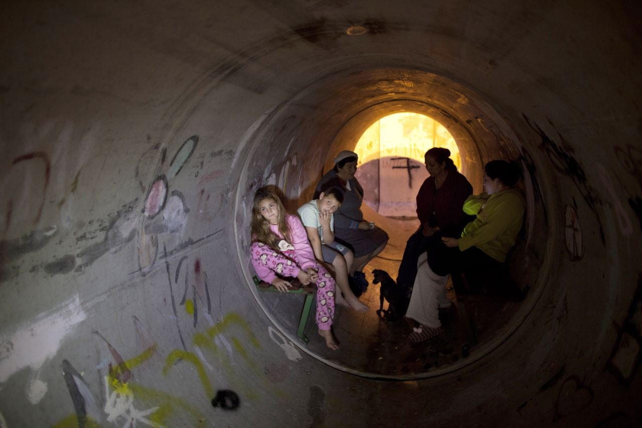 Israelis take cover in a pipe used as a bomb shelter, after a rocket was launched from the Gaza Strip on Thursday, November 15, in Kiryat Malachi, Israel. 