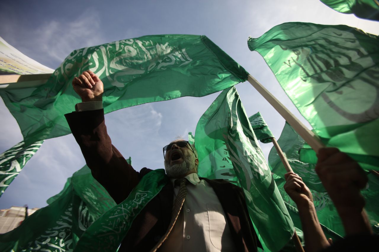 Palestinian protesters hold up the Hamas flag during a rally Friday, November 16, in the West Bank city of Ramallah.