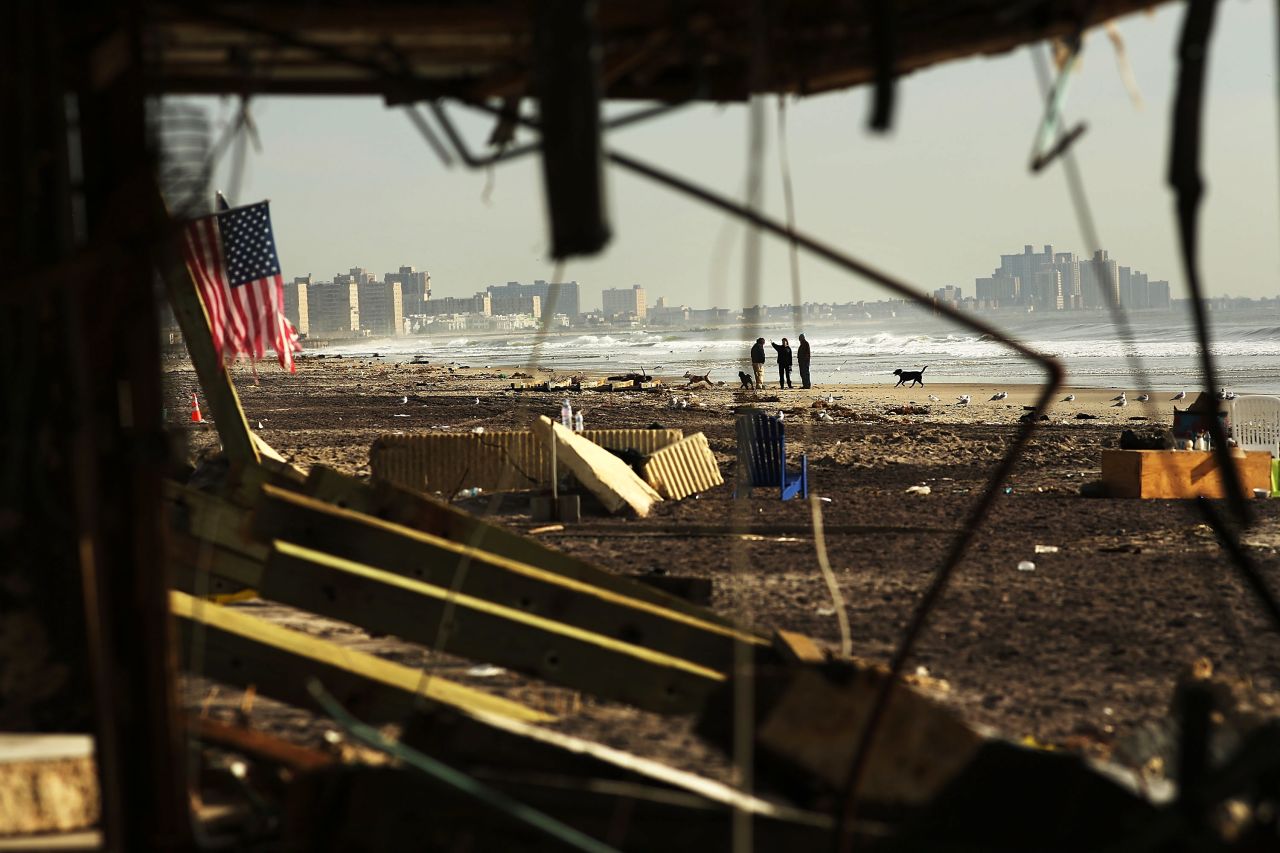 People walk along a beach in the heavily damaged Rockaway neighborhood in the Queens borough of New York on Friday, November 16.